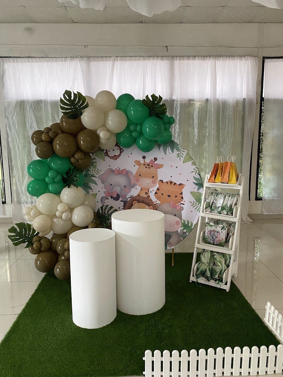 Decoración con banner personalizado, arco de globos y cilindros