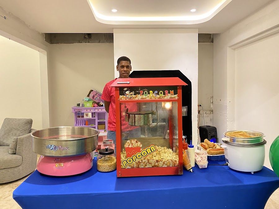 Mesa de snacks con popcorn y algodón de azúcar